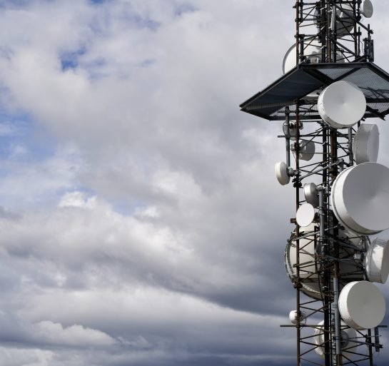 A telecommunications towers against cloudy sky background